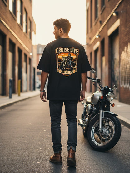 Print 999 black oversized cotton t-shirt with a motorcycle graphic on the back, worn by a man in an urban alleyway.