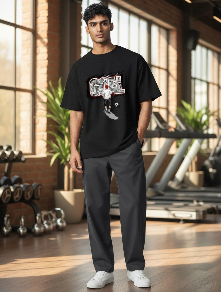 Print 999 black unisex graphic t-shirt featuring a soccer GOAL design, worn by a man in a gym setting.