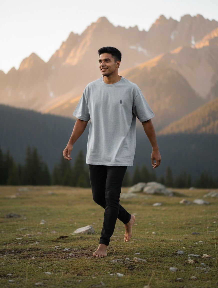 Print 999 grey oversized heavyweight cotton t-shirt with minimal Shiva Trishul chest print worn by a man in nature