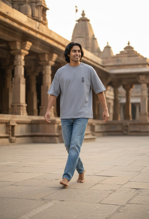 Print 999 oversized grey cotton t-shirt with minimal black Shiva Trishul print, worn by a man at a temple.