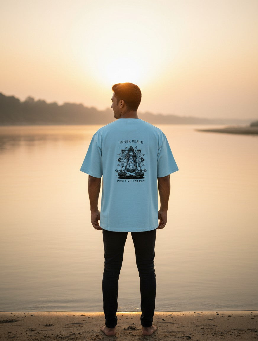 Print 999 light blue oversized cotton t-shirt with Inner Peace graphic on back worn by man at sunset