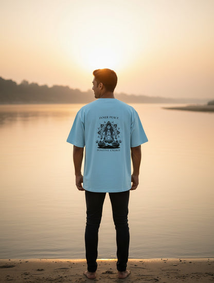 Print 999 light blue oversized cotton t-shirt with Inner Peace graphic on back worn by man at sunset