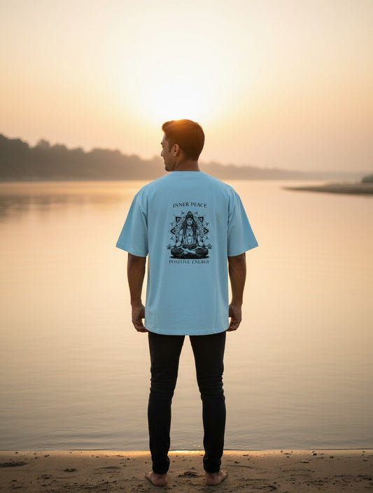 Print 999 light blue oversized cotton t-shirt with Inner Peace graphic on back worn by man at sunset