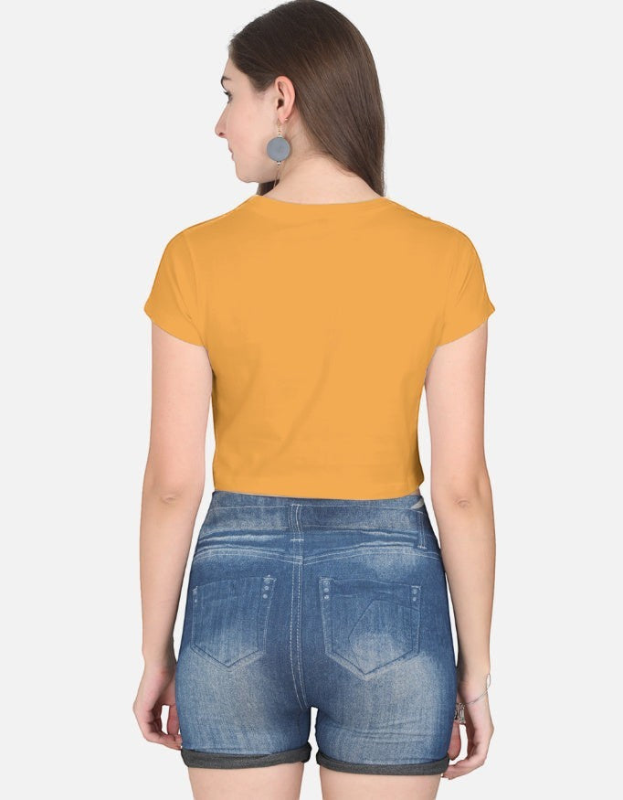 Back view of a woman wearing a mustard yellow Print 999 half-sleeve cotton crop top with blue denim shorts.