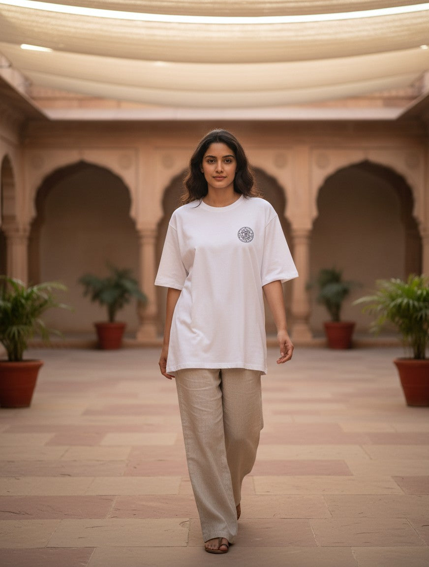 Print 999 white heavyweight cotton oversized t-shirt with Om Sri Yantra chest print worn by a woman in a courtyard