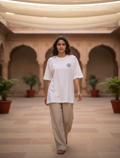 Print 999 white heavyweight cotton oversized t-shirt with Om Sri Yantra chest print worn by a woman in a courtyard