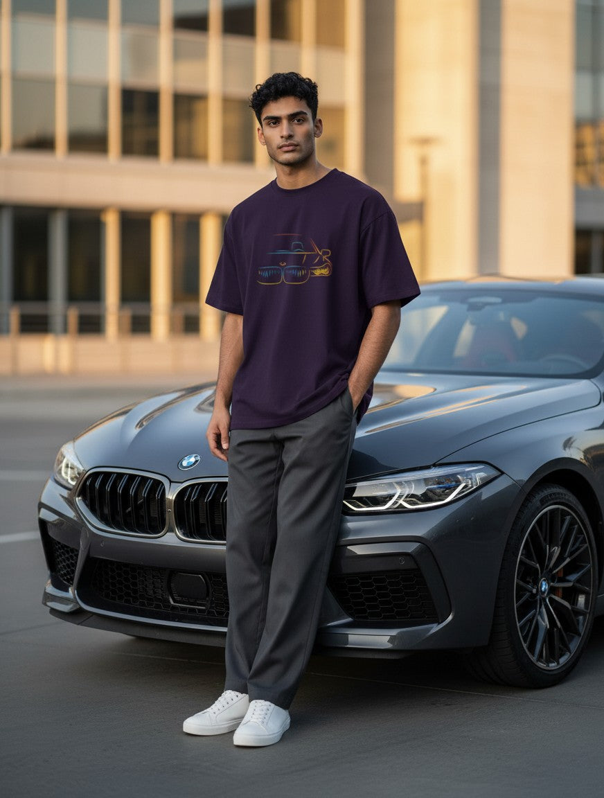 Print 999 oversized purple cotton t-shirt with neon car graphic worn by a man leaning against a luxury car.