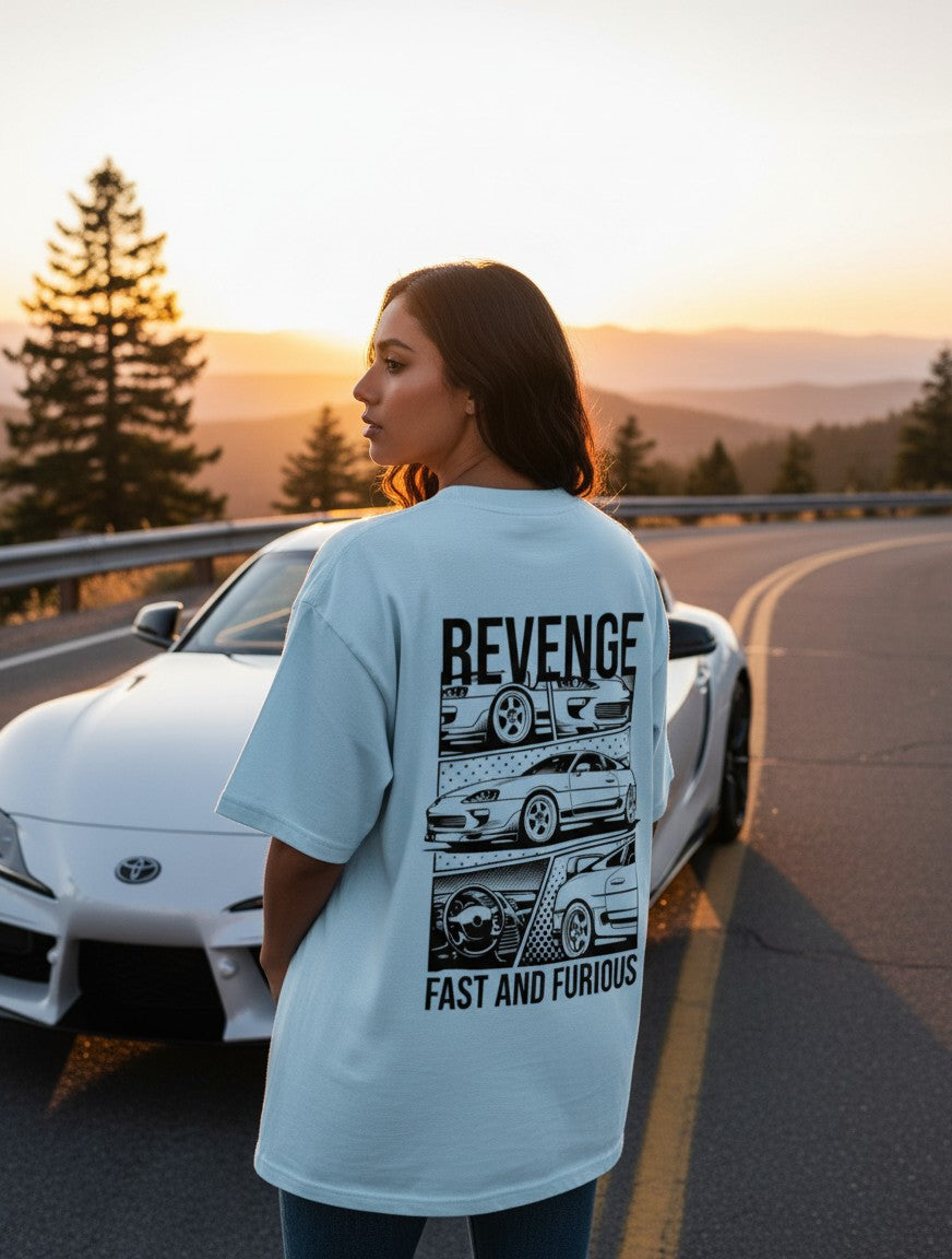Print 999 light blue oversized cotton t-shirt with black street racer car graphic on back, worn by woman at sunset.