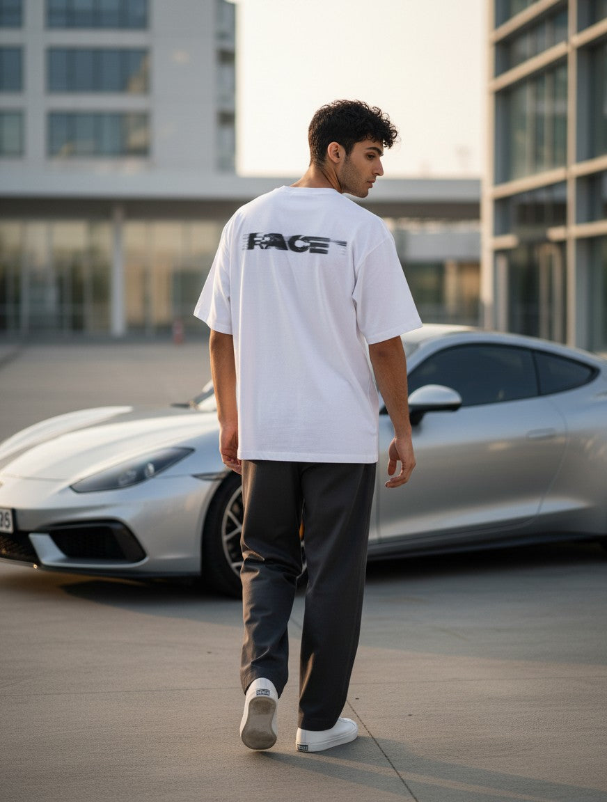 Print 999 white oversized t-shirt with back graphic worn by a man standing near a silver sports car